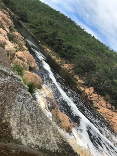 a stream of water on a hill with rocks at Casa Verde na Chapada Diamantina in Palmeiras