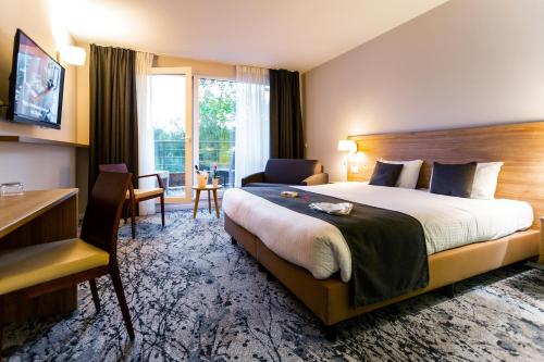 Pokój hotelowy z dużym łóżkiem i biurkiem w obiekcie Utopia Hotel - Art & Nature Hotel w mieście Mons
