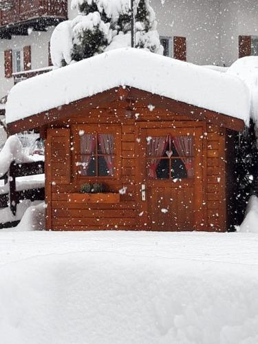 a building covered in snow in a yard at Hotel Garni Walter in Ortisei