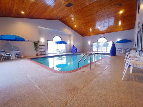 a large indoor pool with blue umbrellas in a building at Country Inn & Suites by Radisson, Freeport, IL in Freeport