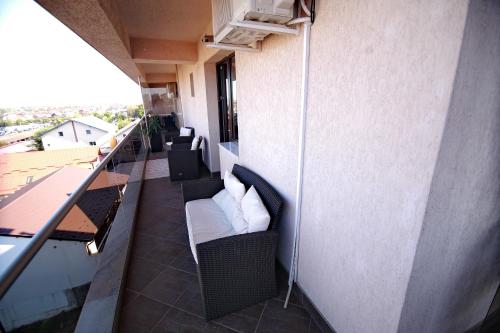 a balcony with a couch and chairs on a building at Casa Muntenească Alessandro in Piteşti
