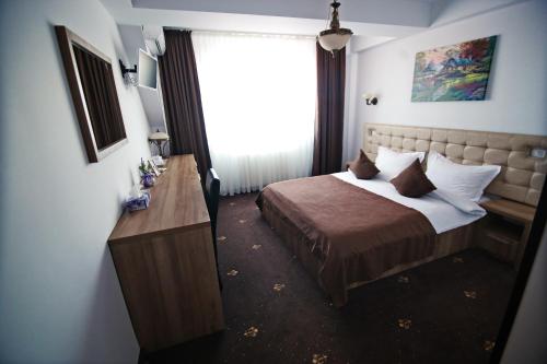 a hotel room with a bed and a window at Casa Muntenească Alessandro in Piteşti