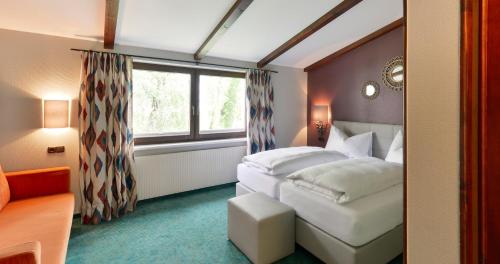 Habitación de hotel con cama y ventana en Schlosshotel Dörflinger en Bludenz