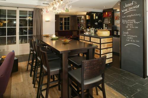 a kitchen with a table and a bar with chairs at Le Mirabeau Resort & Spa in Zermatt