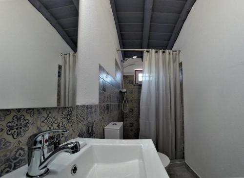 a bathroom with a sink and a shower at 17 da Rua da Estação in São Pedro do Corval