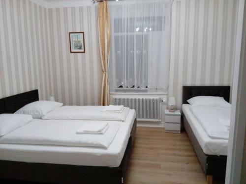 two beds in a hotel room with a window at Liahof in Ullared