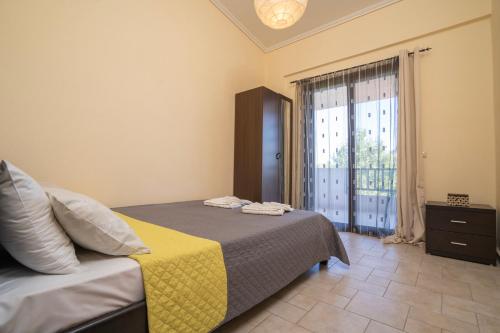 a bedroom with a bed and a large window at Villa Katerina in Siviri