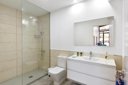 a bathroom with a toilet and a sink and a mirror at Finca Solis family cottage PM in Vega de San Mateo