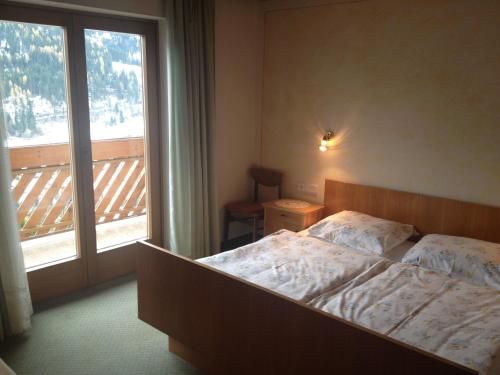 a bedroom with a bed and a large window at Gästehaus Lisbeth in Bad Kleinkirchheim