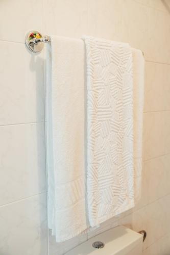two towels hanging on a towel rack in a bathroom at Dona Fina Guest House in Mirandela