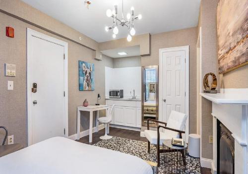 a bedroom with a bed and a desk and a fireplace at Suites At 143 Arlington Street in Boston