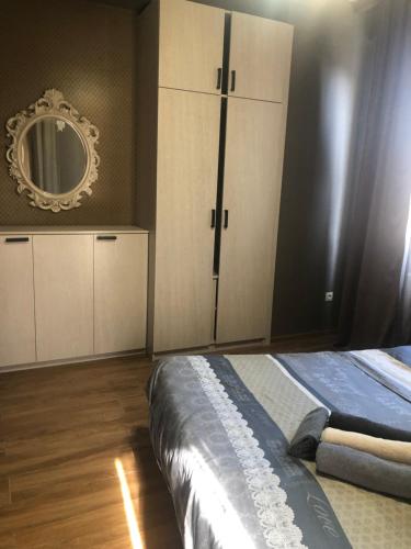 a bedroom with a bed and a mirror on the wall at Dona Palace Apartments in Tbilisi City