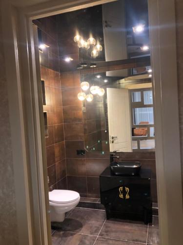 a bathroom with a toilet and a sink and a mirror at Dona Palace Apartments in Tbilisi City