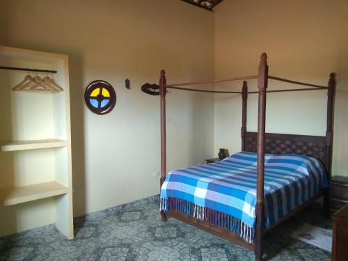 a bedroom with a bed with a blue and white comforter at Casa Litoral Sul - Praia Bela/ PB in Pitimbu