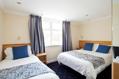 a hotel room with two beds and a window at Queens Mansions: Hesketh Apartment in Blackpool