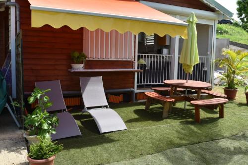 a patio with a table and chairs and an umbrella at Lokation gwada in Sainte-Anne