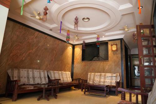 a living room with a couch and chairs and a ceiling at Durga residency in Tirupati