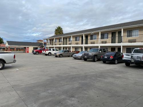 a parking lot with cars parked in front of a building at Colonial Motel in Santa Maria