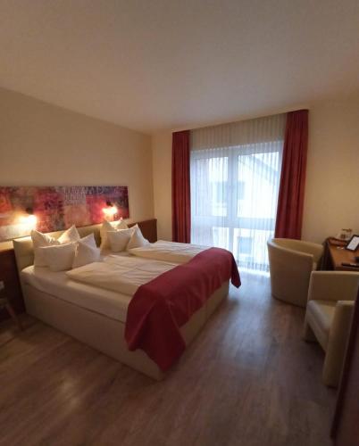 a bedroom with a large bed and a large window at Arador-City Hotel in Bad Oeynhausen