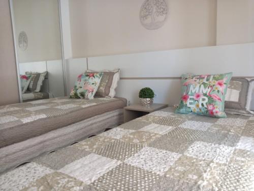 ボンビーニャスにあるMariscal 02 dormitórios, 80m do mar, com piscinaの寝室に並んで置かれた2つのベッド