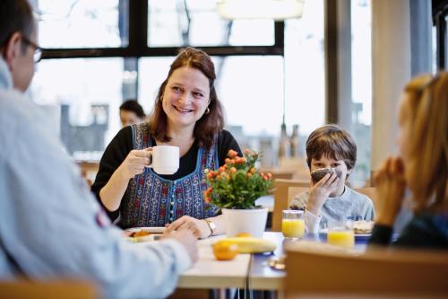 a woman sitting at a table eating with a child at martas Gästehäuser Hauptbahnhof Berlin in Berlin