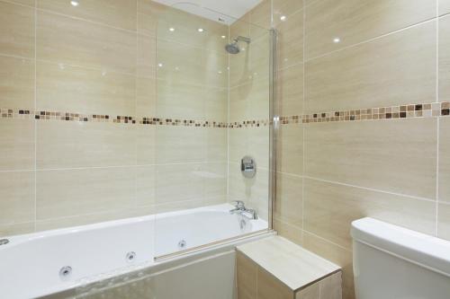 a bathroom with a tub and a toilet and a sink at Queens Mansions: The Maisonette in Blackpool