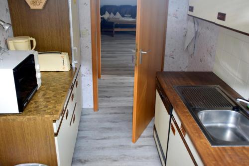 a small kitchen with a sink and a hallway at FeWo Afferde in Hameln
