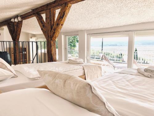 a room with four white beds and a large window at Apartment Laurus in Portorož
