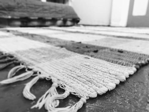 a white rug laying on the ground on the floor at FARINHA DE PAU - ECO B&B in Tarrafal