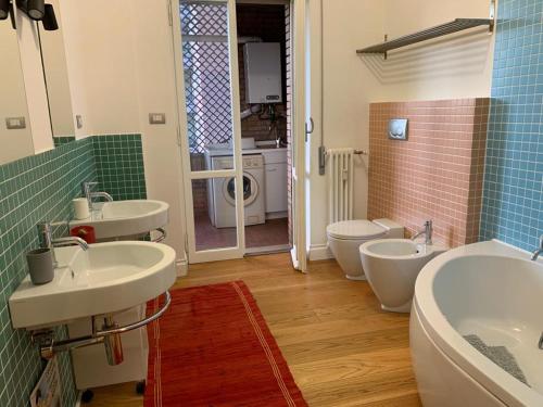 a bathroom with three sinks and a toilet in it at Casa Mentana in Terni