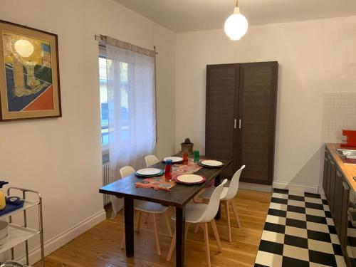 a dining room with a table and white chairs at Casa Mentana in Terni
