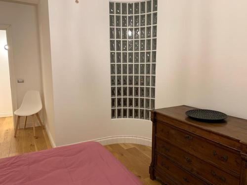 a bedroom with a wooden dresser and a glass wall at Casa Mentana in Terni