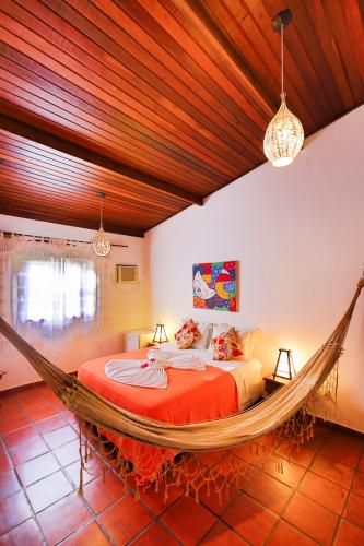 a bedroom with a hammock bed in a room at Pousada Enseada Dos Golfinhos in Pipa