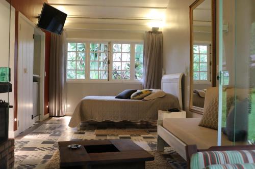 a bedroom with a bed and a large window at Auberge Suisse Pousada in Nova Friburgo