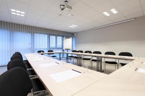 a conference room with a long table and chairs at The Originals City, L'Haut' Aile, Coquelles-Calais Tunnel s/Manche L'HAUTAILE in Coquelles