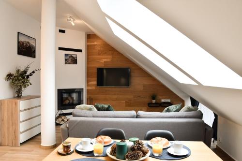 a living room with a couch and a table at Apartamenty Forma Tatrica in Zakopane