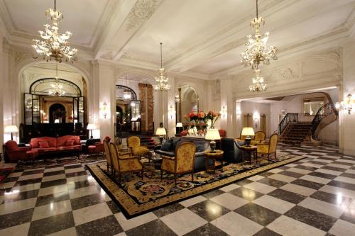 a large room with a lobby with chandeliers at Hotel Le Plaza Brussels in Brussels
