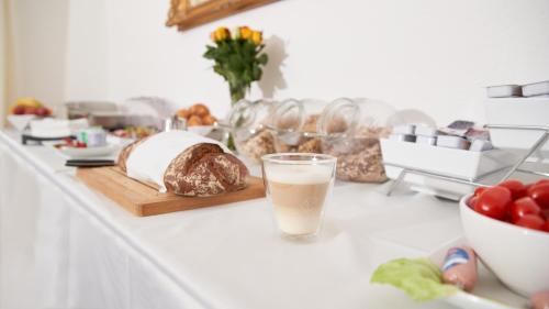 einen Tisch mit einem Glas Milch und Brot in der Unterkunft Hotel Moguntia in Mainz