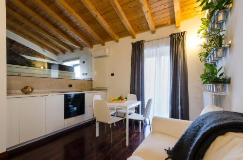 cocina y sala de estar con mesa y sillas en Pietranera Apartments, en Catania