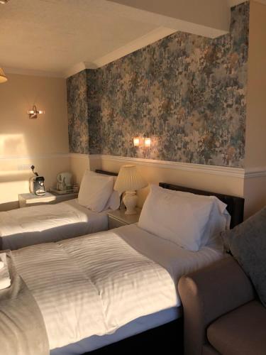 a hotel room with two beds and a couch at The Purple Tree Guest House in Torquay