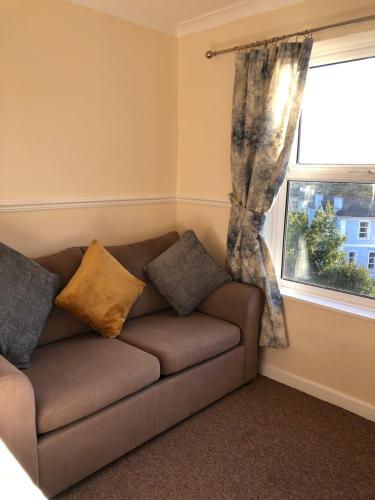 a couch in a room with a window at The Purple Tree Guest House in Torquay