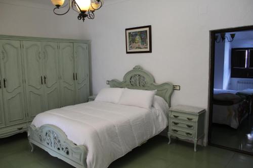 a bedroom with a bed and a dresser and a mirror at Casa Alcaida in Quesada