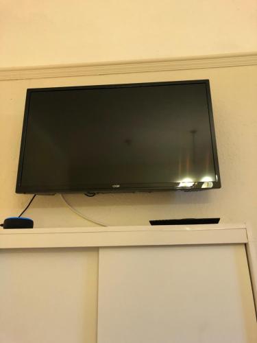 a flat screen tv sitting on top of a shelf at The Purple Tree Guest House in Torquay
