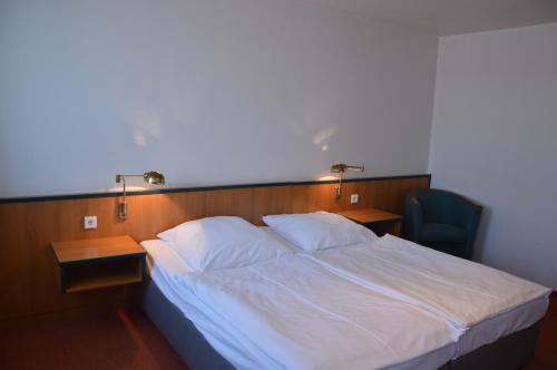 a bedroom with a bed and two desks and a chair at Centrum Hotel Commerz am Bahnhof Altona in Hamburg