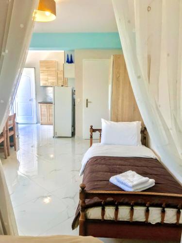 a bedroom with a bed and a kitchen with a refrigerator at SEMIRAMIS SUITES with pool in Kalamata