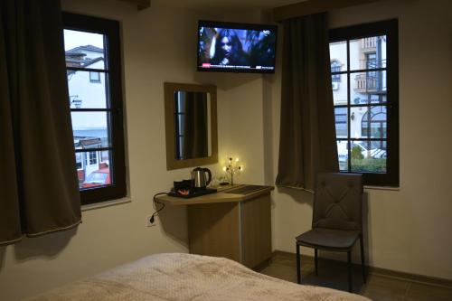Un dormitorio con una cama, un escritorio y un televisor. en Port Villa, en Ohrid