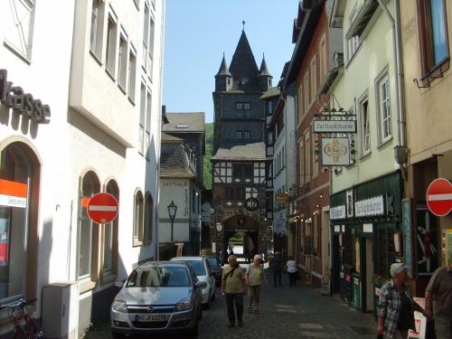 a group of people walking down a street with a clock tower at Schau-Rhein#2 - on Top of Bacharach, Rhineview in Bacharach