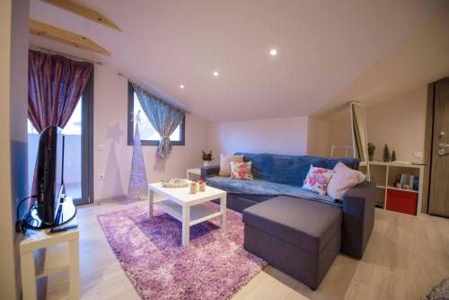 a living room with a blue couch and a table at New Loft Polixeni in Ioannina