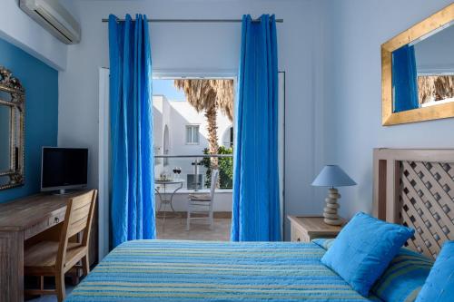 1 dormitorio con cama, escritorio y ventana en Alesahne Beach Hotel, en Kamari