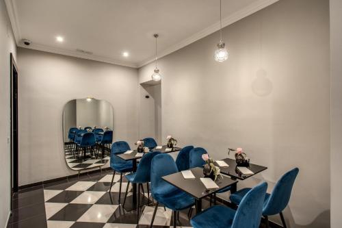 a restaurant with blue chairs and tables and a mirror at Relais De La Poste in Rome